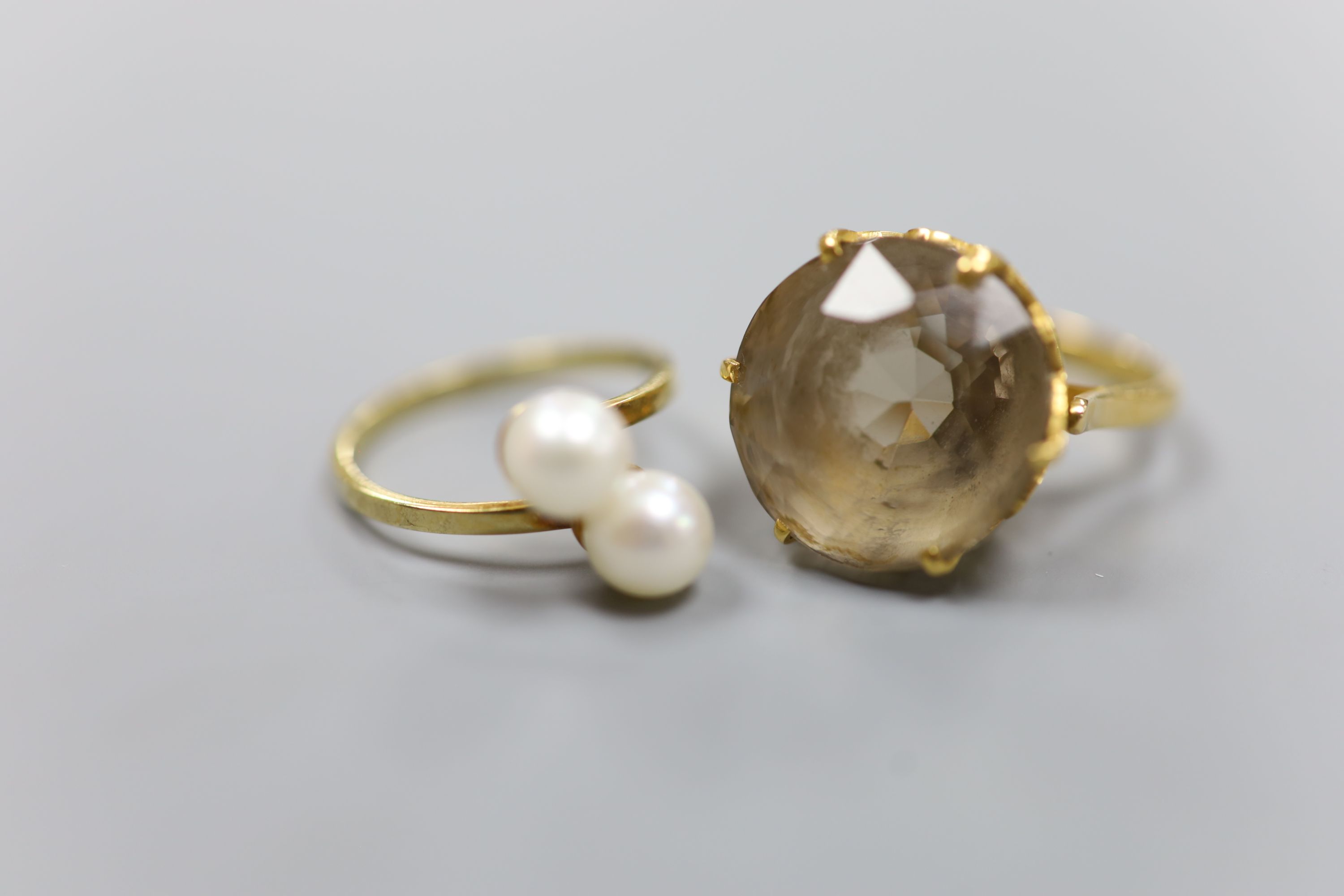 A yellow metal and smoky quartz dress ring, gross 8.2 grams and a 585 and two stone cultured pearl set crossover ring, gross 2.3 grams.